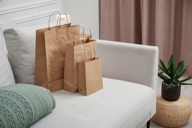Photo of Paper bags and plaid on sofa at home