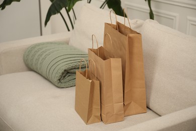 Photo of Paper bags and plaid on sofa at home