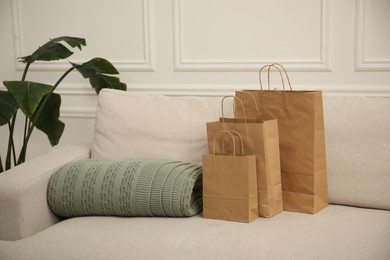 Photo of Paper bags and plaid on sofa at home