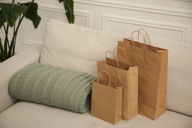 Photo of Paper bags and plaid on sofa at home