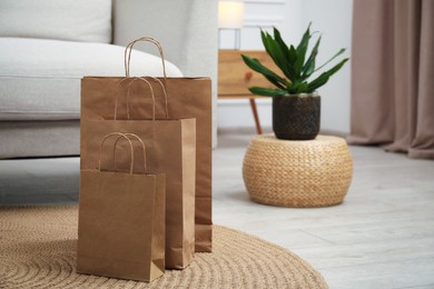 Photo of Paper bags and plant on floor at home. Space for text