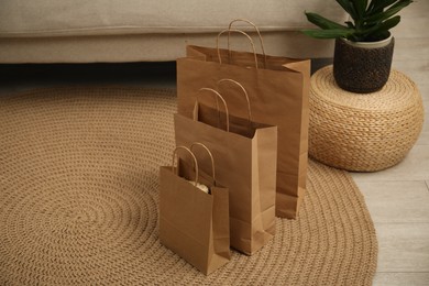 Photo of Paper bags and plant on floor at home. Space for text
