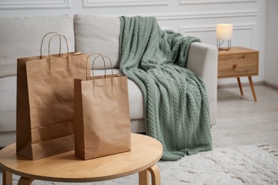 Photo of Paper bags on wooden table at home. Space for text