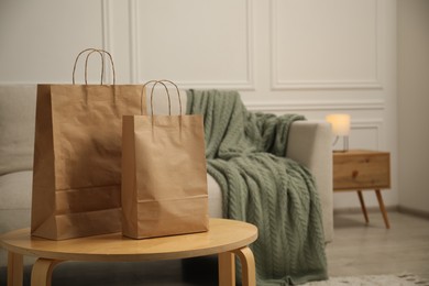 Photo of Paper bags on wooden table at home. Space for text