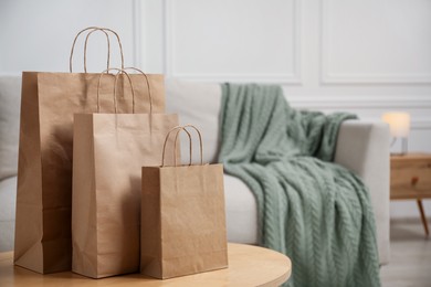 Photo of Paper bags on wooden table at home. Space for text