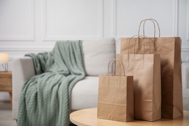 Photo of Paper bags on wooden table at home. Space for text
