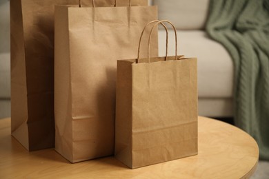 Photo of Paper bags on wooden table at home, closeup