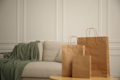 Photo of Paper bags on wooden table at home. Space for text