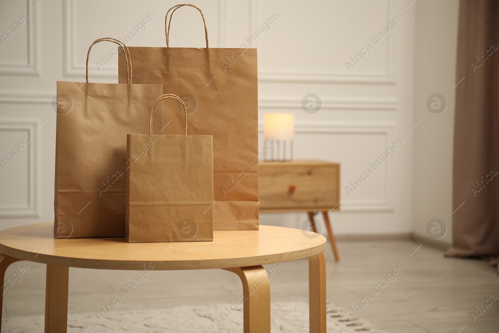 Photo of Paper bags on wooden table at home. Space for text