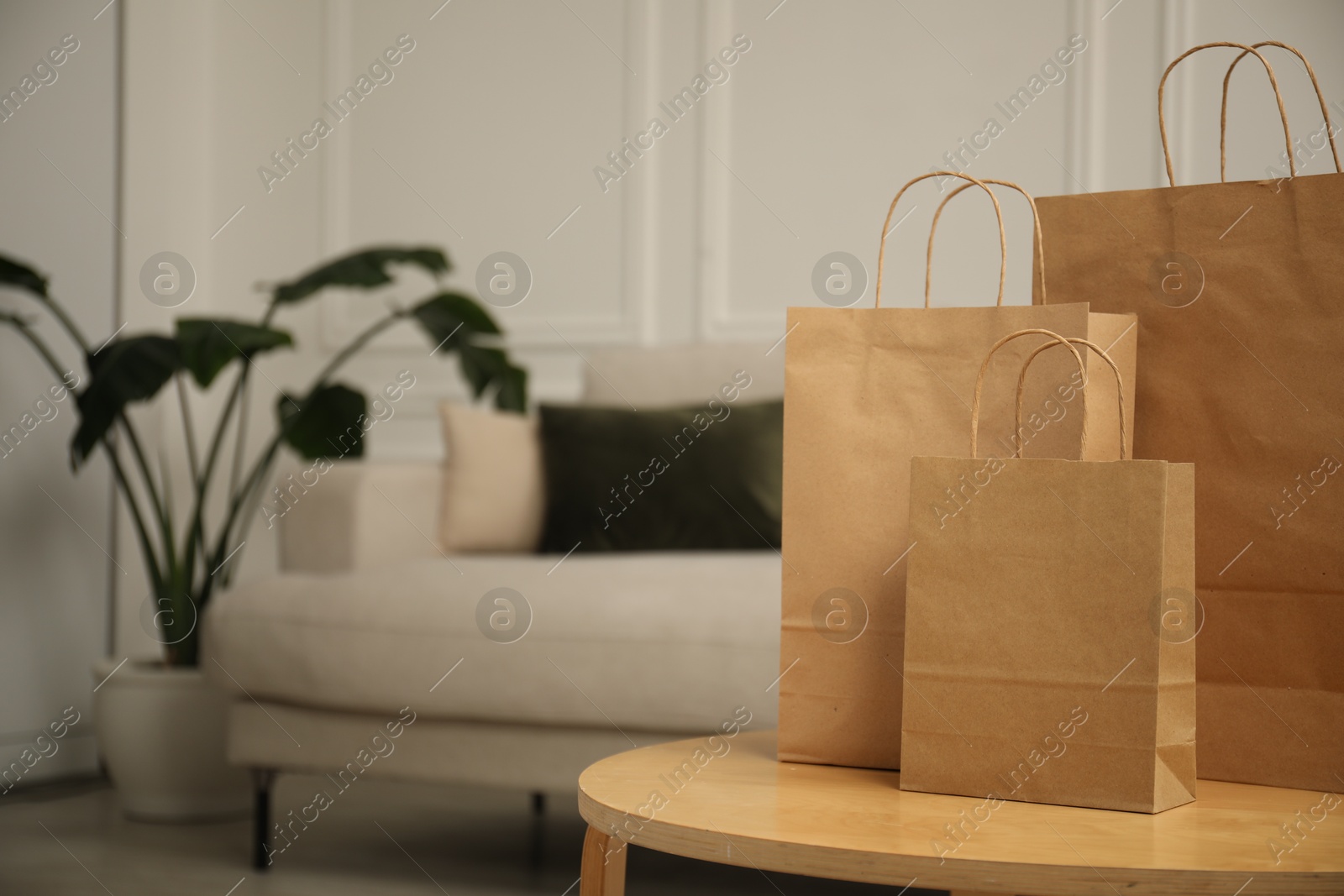 Photo of Paper bags on wooden table at home. Space for text