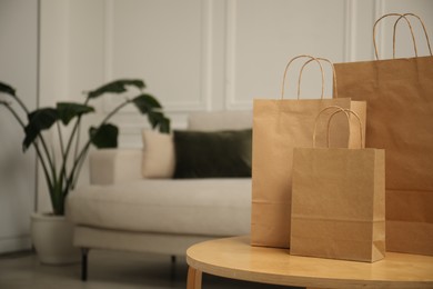 Photo of Paper bags on wooden table at home. Space for text