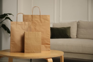 Photo of Paper bags on wooden table at home. Space for text