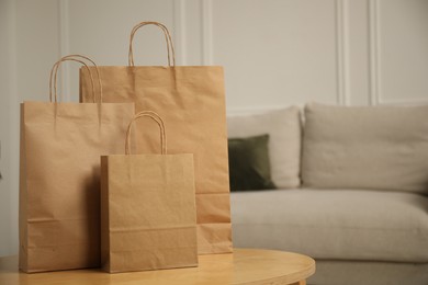 Photo of Paper bags on wooden table at home. Space for text