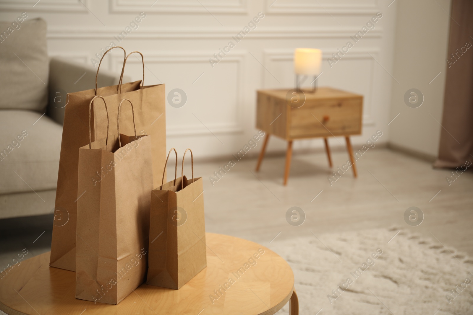Photo of Paper bags on wooden table at home. Space for text