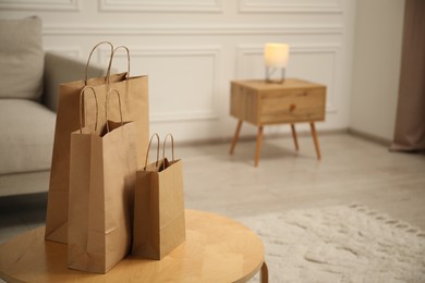 Photo of Paper bags on wooden table at home. Space for text