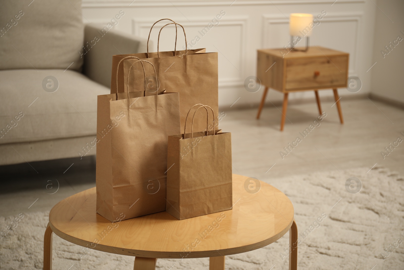 Photo of Paper bags on wooden table at home. Space for text