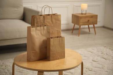 Photo of Paper bags on wooden table at home. Space for text