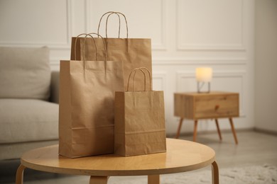 Photo of Paper bags on wooden table at home. Space for text
