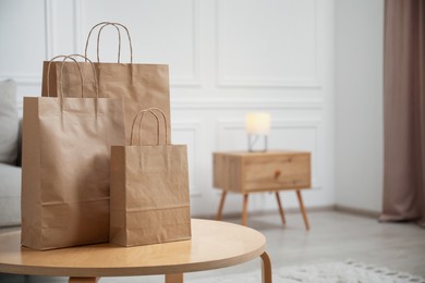 Photo of Paper bags on wooden table at home. Space for text