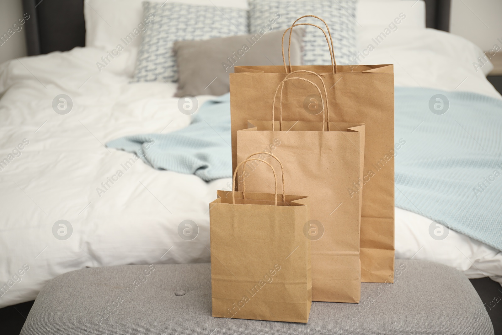 Photo of Paper bags on bench near bed at home. Space for text