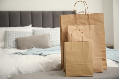 Photo of Paper bags on bench near bed at home. Space for text