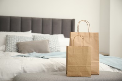 Photo of Paper bags on bench near bed at home. Space for text