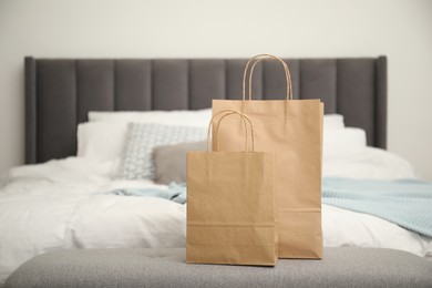 Photo of Paper bags on bench near bed at home. Space for text