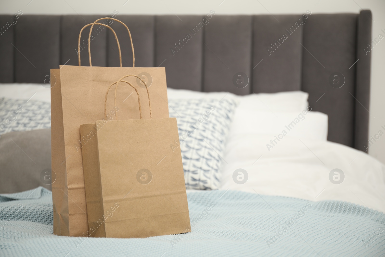 Photo of Paper bags on bed at home. Space for text