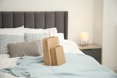 Photo of Paper shopping bags on bed at home