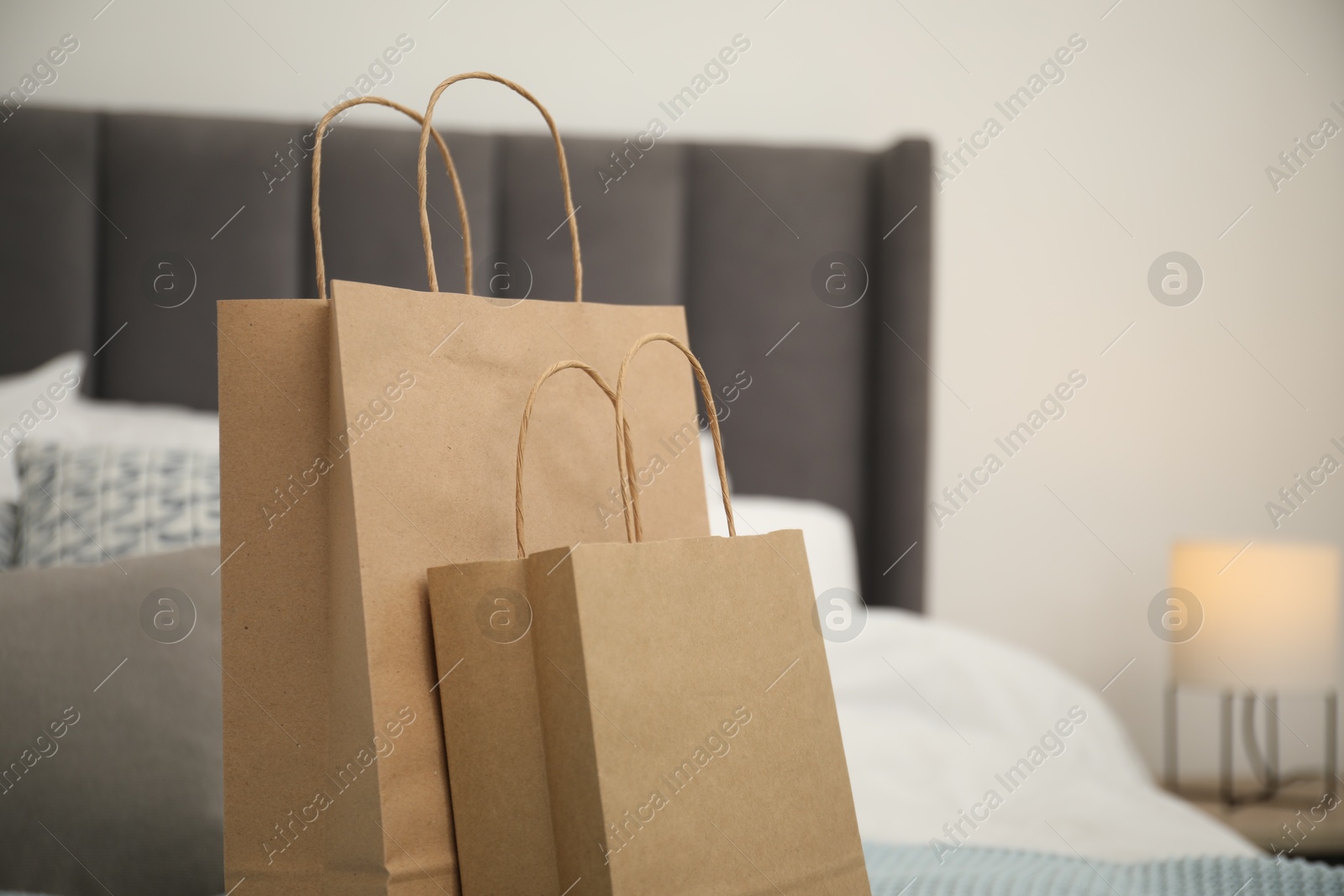 Photo of Paper bags on bed at home. Space for text