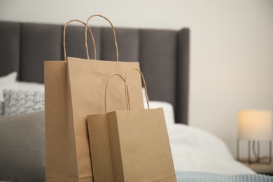 Photo of Paper bags on bed at home. Space for text