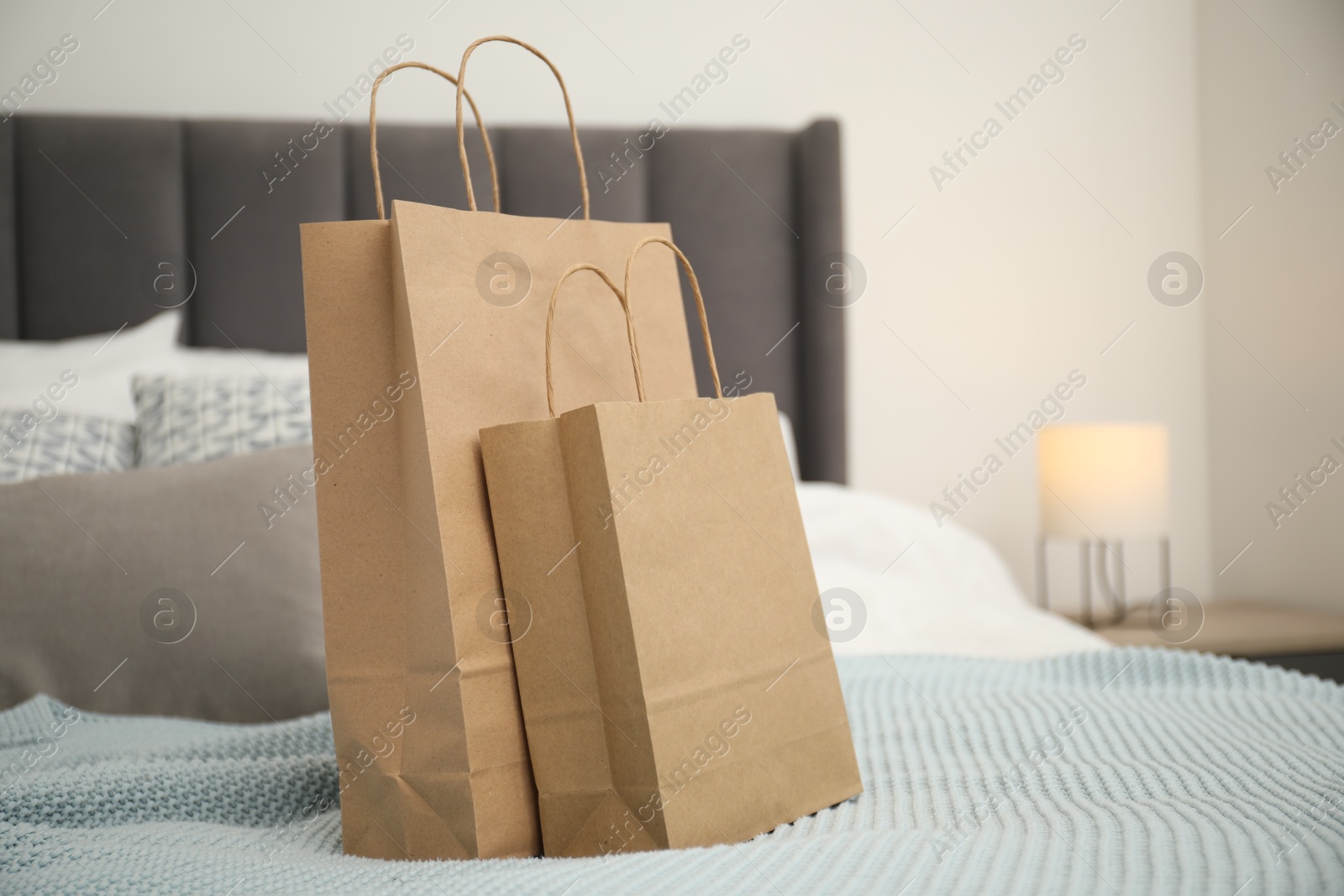 Photo of Paper shopping bags on bed at home