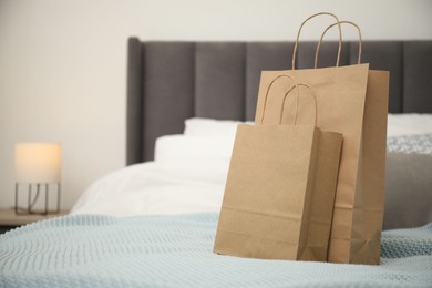 Photo of Paper bags on bed at home. Space for text