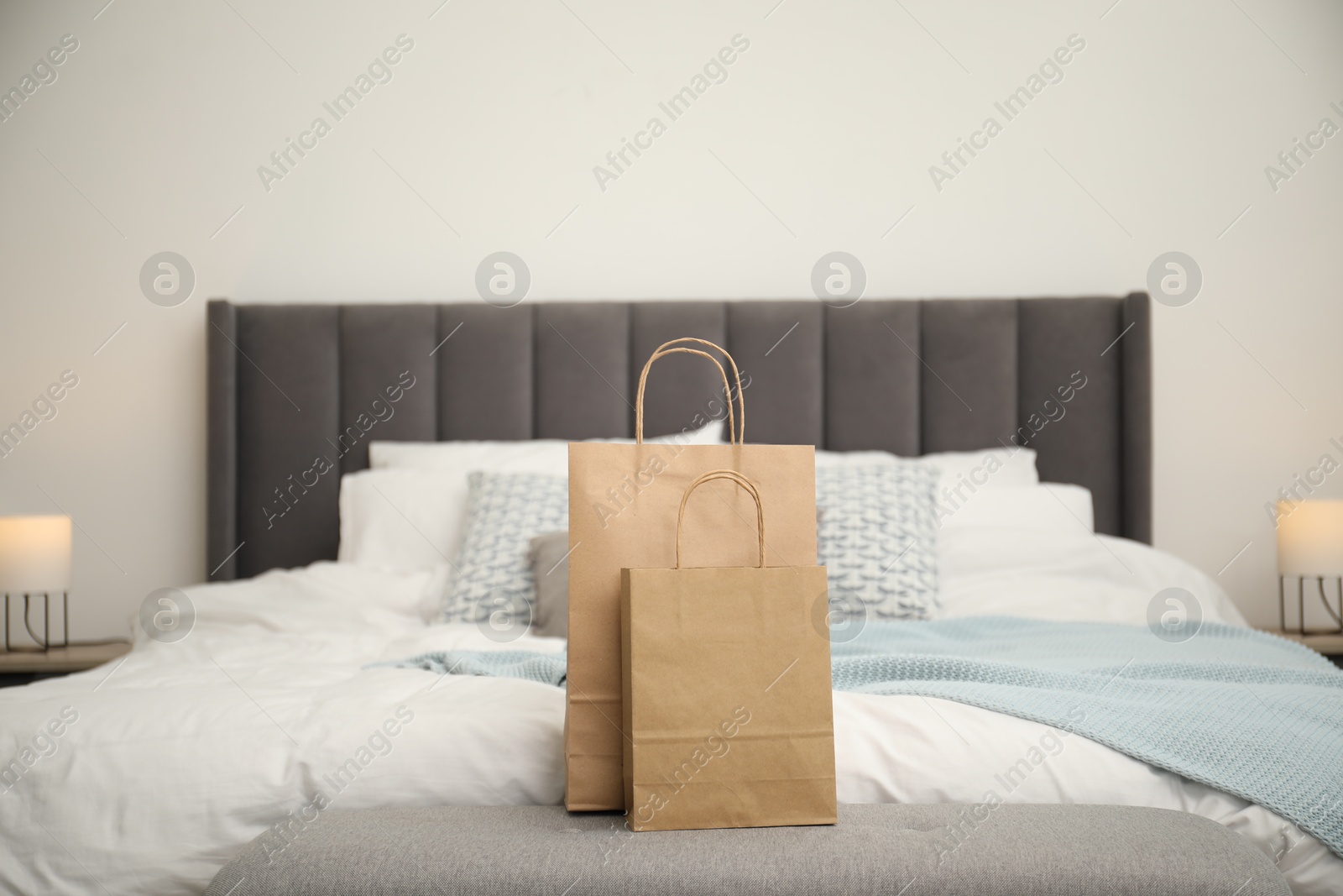 Photo of Paper shopping bags on bed at home