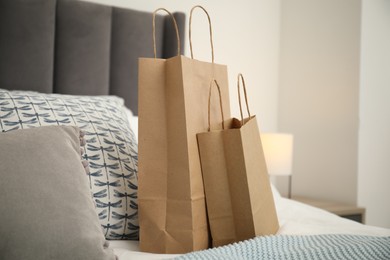 Photo of Paper shopping bags on bed at home