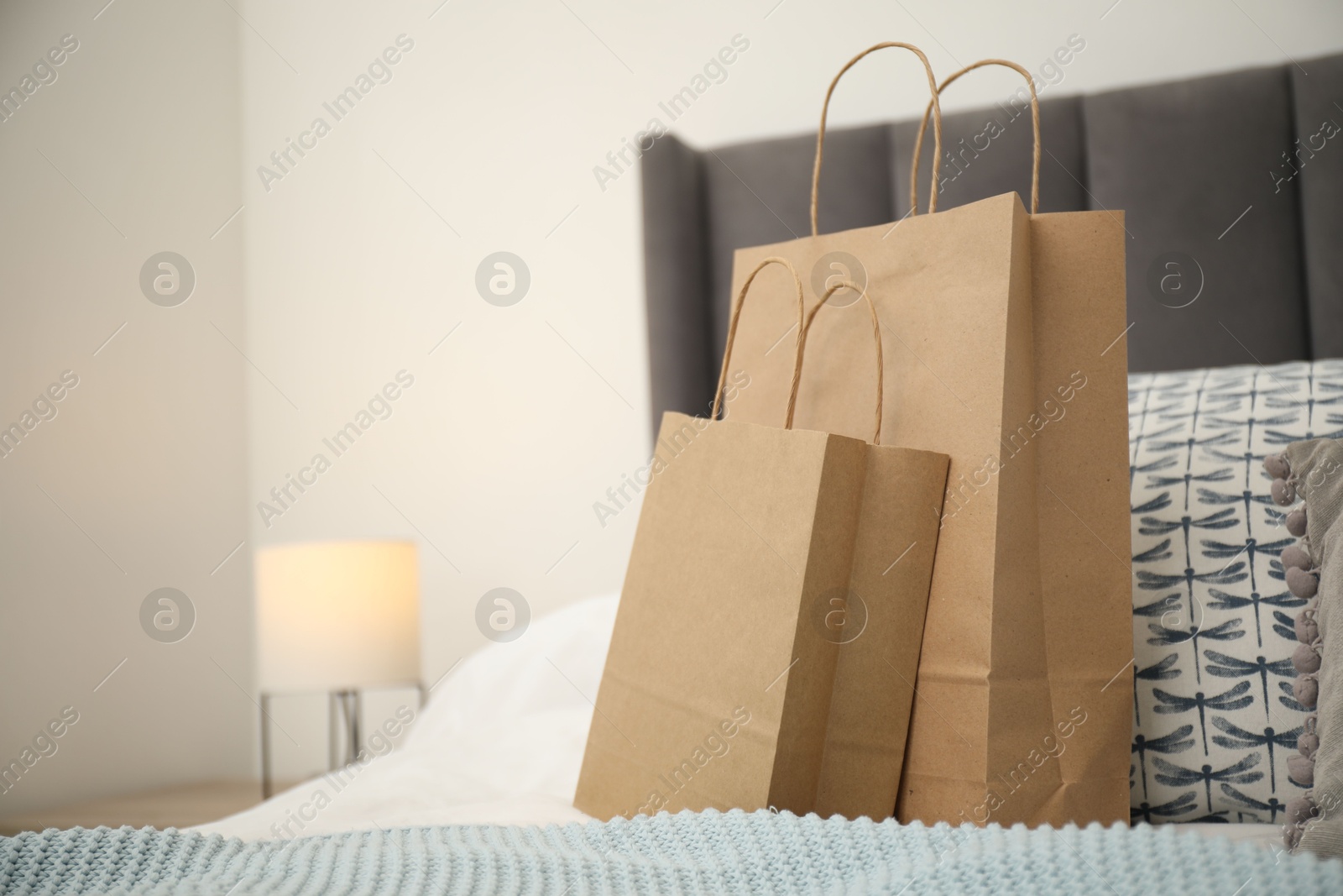 Photo of Paper bags on bed at home. Space for text