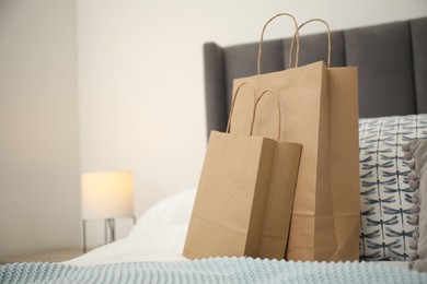 Photo of Paper bags on bed at home. Space for text