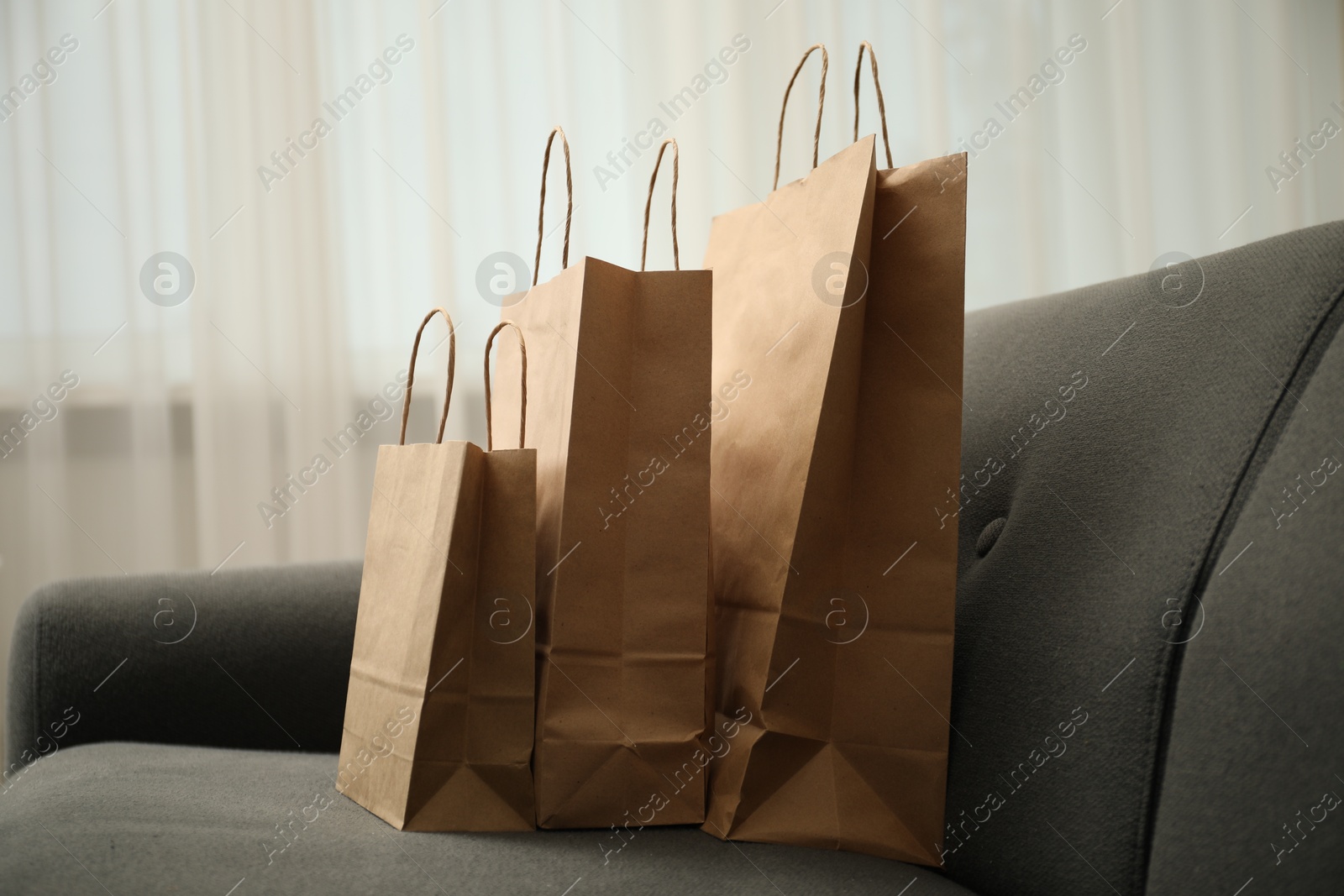 Photo of Paper shopping bags on sofa at home