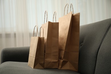 Photo of Paper shopping bags on sofa at home