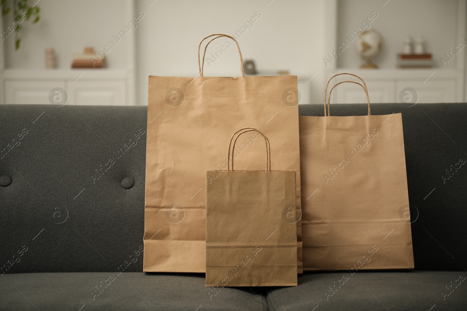 Paper shopping bags on sofa at home Photo of Paper shopping bags on sofa at home