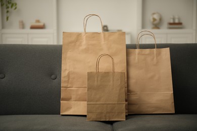 Photo of Paper shopping bags on sofa at home