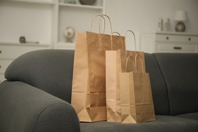 Photo of Paper shopping bags on sofa at home
