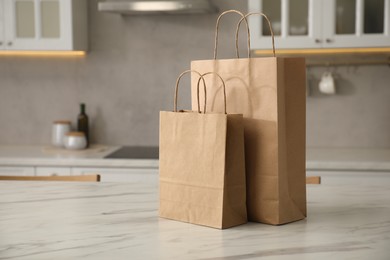 Photo of Paper bags on white marble table in kitchen. Space for text