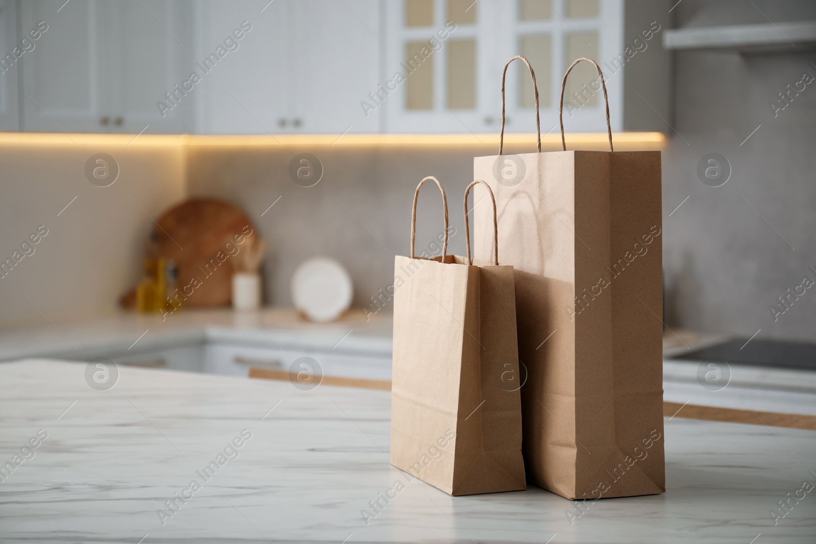 Paper bags on white marble table in kitchen. Space for text Photo of Paper bags on white marble table in kitchen. Space for text