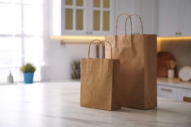 Photo of Paper bags on white marble table in kitchen. Space for text