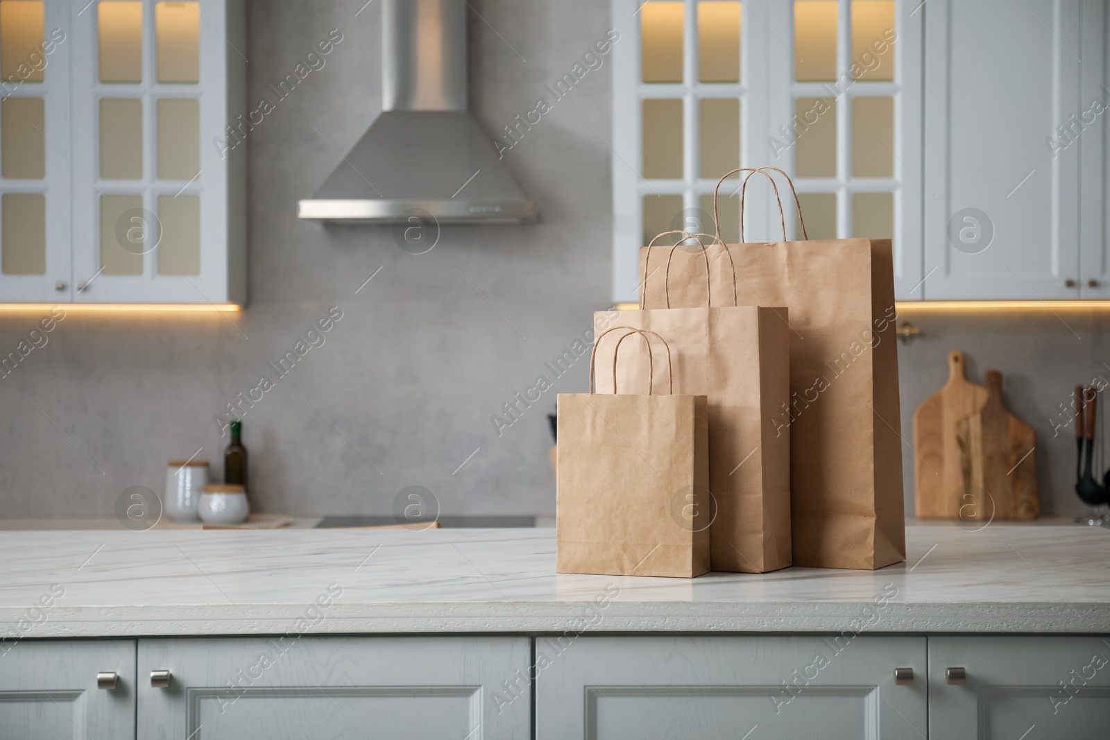 Paper bags on white marble table in kitchen. Space for text Photo of Paper bags on white marble table in kitchen. Space for text