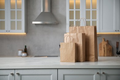 Photo of Paper bags on white marble table in kitchen. Space for text