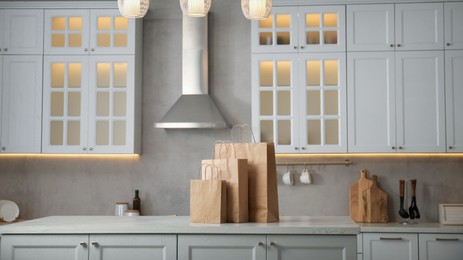 Photo of Paper bags on white marble table in kitchen. Space for text