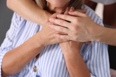 Photo of Son hugging his mother indoors, closeup. Family bonding