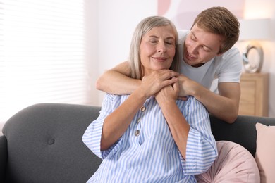 Photo of Happy son hugging his mother at home. Space for text